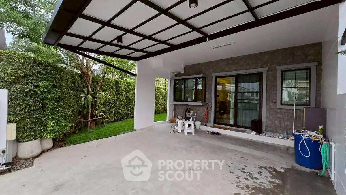 Modern home exterior with covered patio and lush greenery