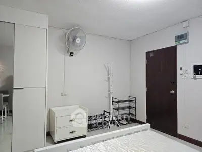Minimalist bedroom with white furniture and wall-mounted fan