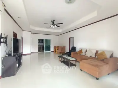 Spacious living room with modern furniture and ceiling fan