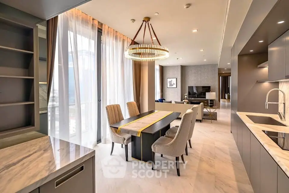 Luxurious open-plan living and dining area with modern kitchen and elegant lighting.