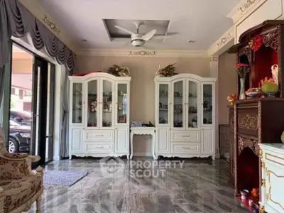 Elegant living room with classic white cabinets and marble flooring, featuring luxurious decor and ample natural light.