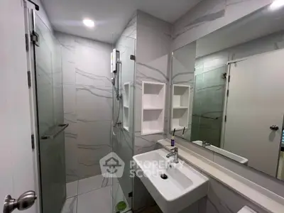 Modern bathroom with sleek design, featuring a spacious shower and elegant fixtures.