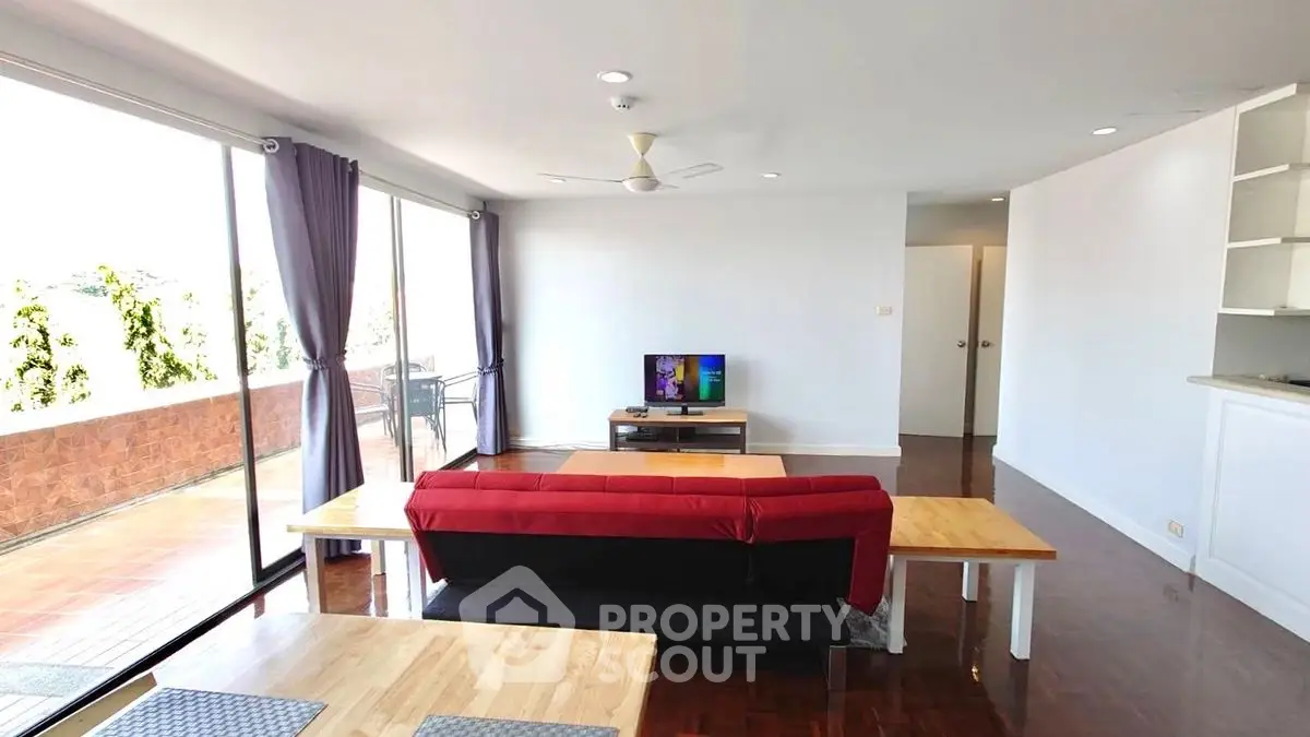 Spacious living room with modern decor and large balcony access