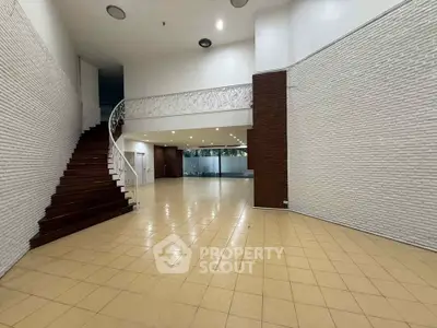 Spacious open interior with elegant staircase and modern design, perfect for versatile real estate opportunities.