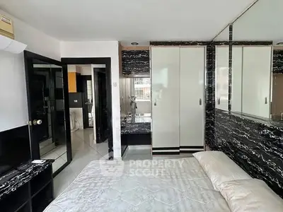 Modern bedroom with sleek black and white decor and mirrored accents