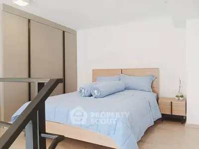 Modern bedroom with stylish wooden furniture and cozy blue bedding
