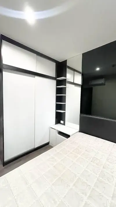 Modern bedroom with sleek built-in wardrobe and cozy bed in stylish apartment.