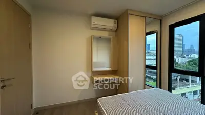 Modern bedroom with city view, featuring built-in wardrobe and air conditioning.