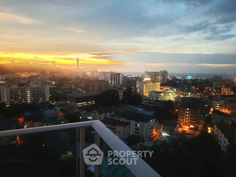 Stunning cityscape view from a high-rise balcony at sunset, showcasing urban skyline and vibrant horizon.