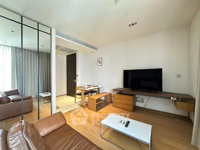 Modern living room with leather sofas, TV, and wooden furniture in a stylish apartment.