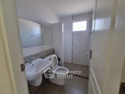 Modern bathroom with sleek design and natural light, featuring a spacious shower area and contemporary fixtures.
