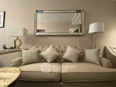 Elegant living room with plush sofa, stylish lamps, and chic mirror enhancing the modern decor.