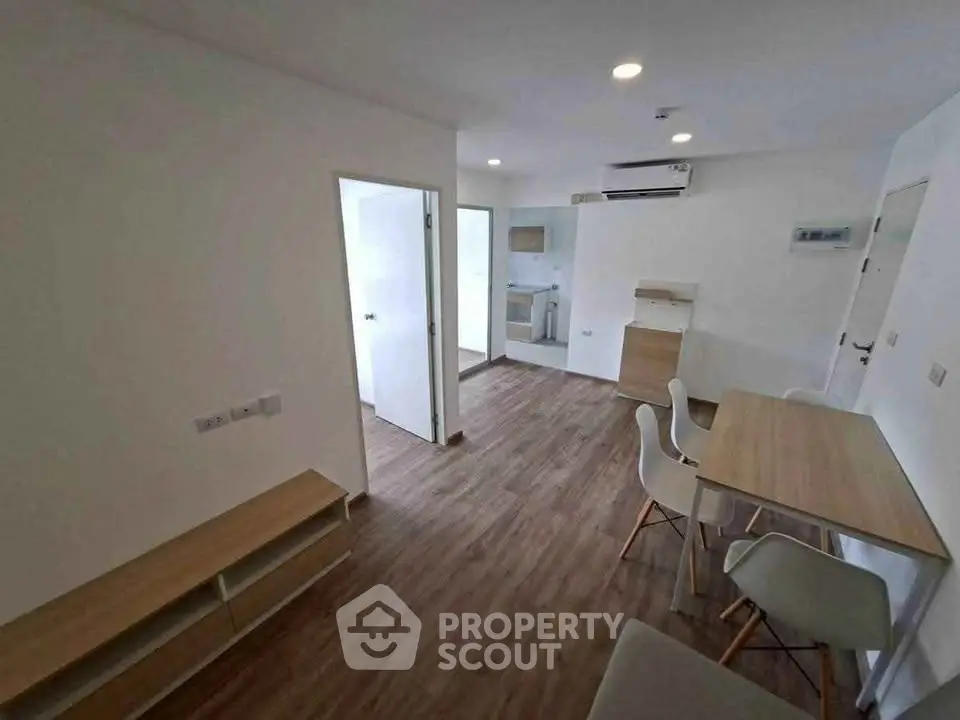 Modern apartment with open layout, featuring sleek wooden flooring and minimalist furniture design.