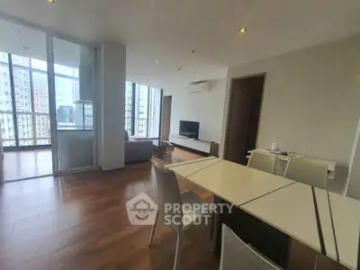 Spacious modern living room with balcony and city view, perfect for urban living.