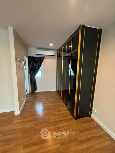 Spacious bedroom with elegant wooden flooring and modern wardrobe design