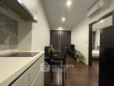 Modern apartment interior with sleek kitchen and cozy living area, featuring stylish furniture and elegant decor.