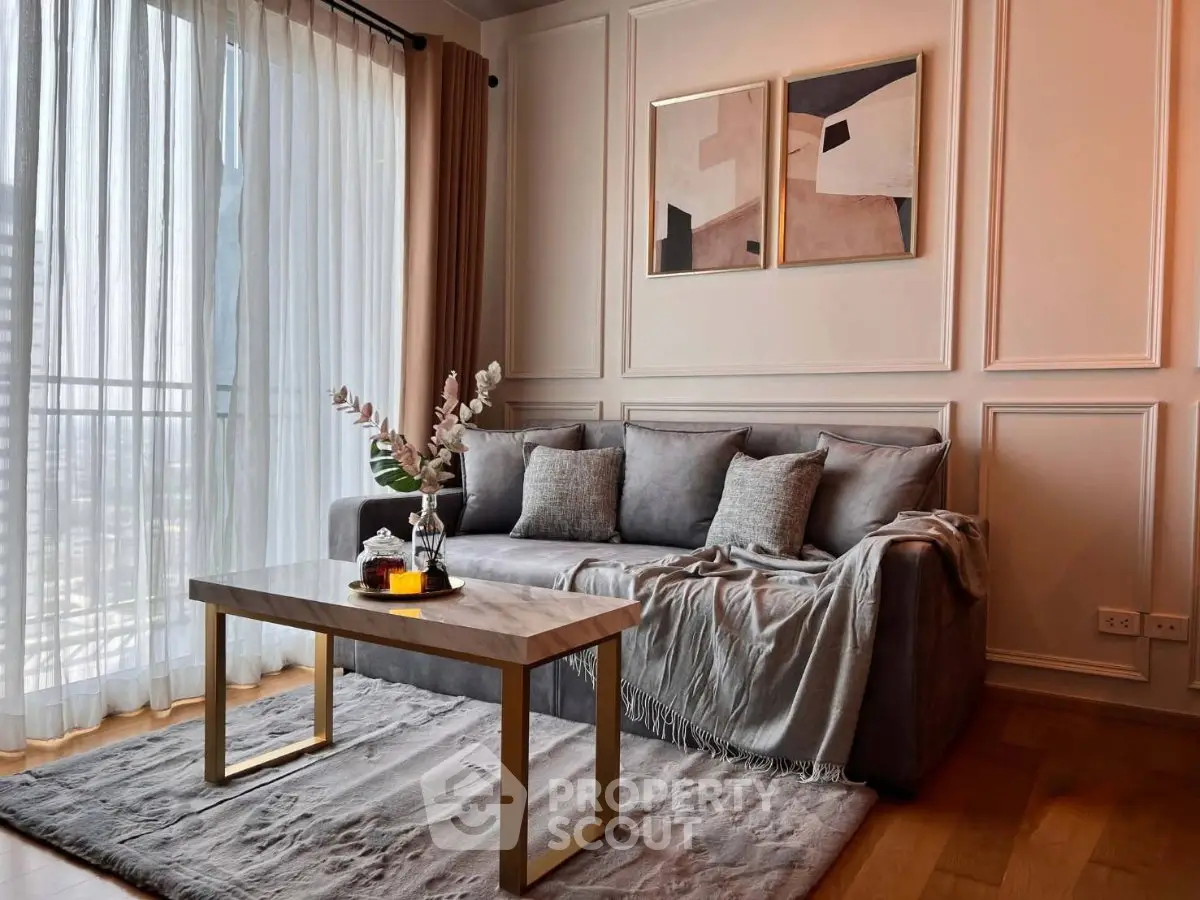 Elegant living room with modern decor, cozy gray sofa, and large window offering natural light and city view.