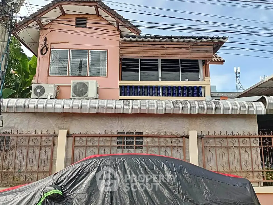 Charming two-story house with balcony and air conditioning units, ideal for comfortable living.