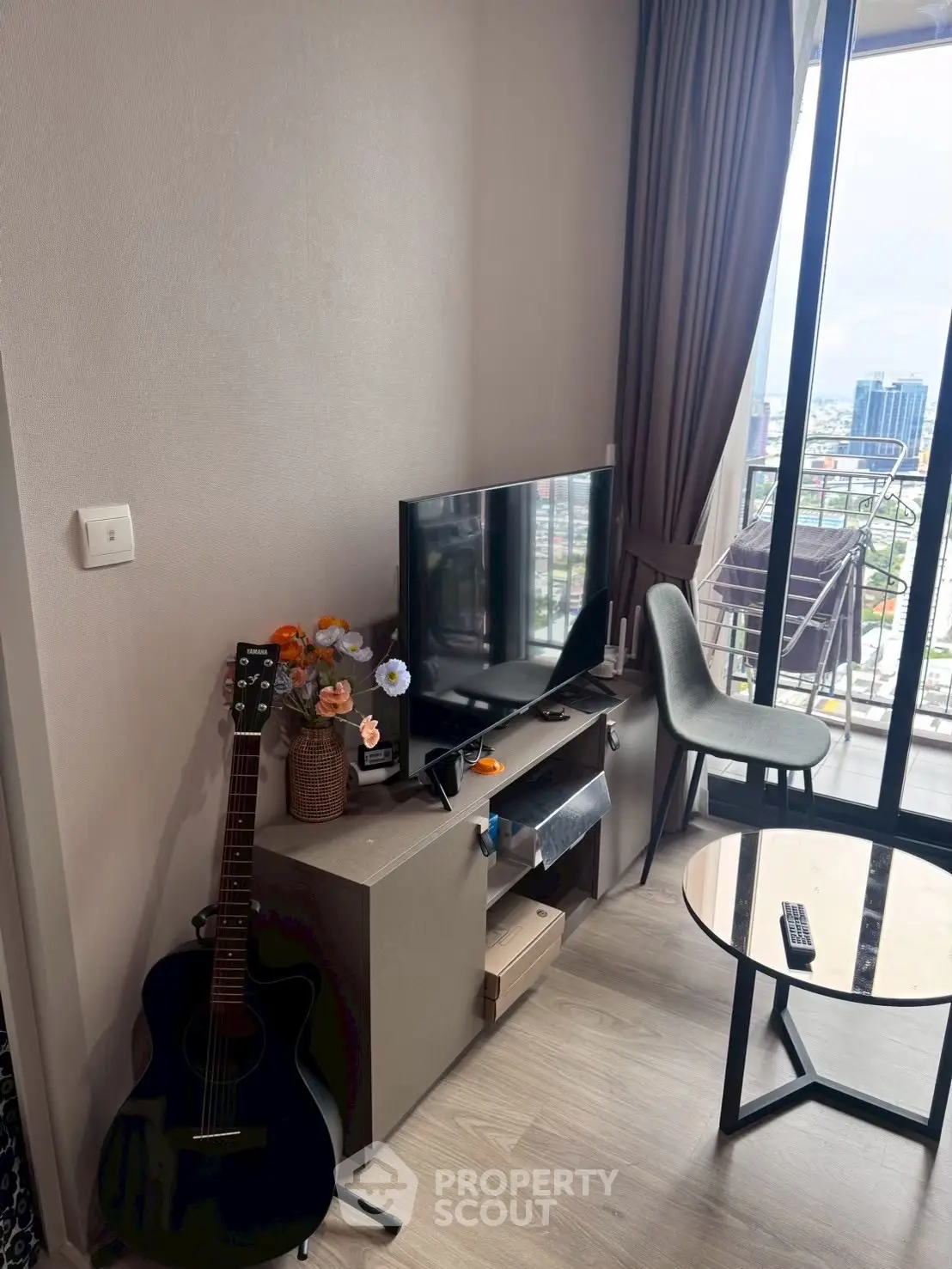 Modern living room with city view, guitar, and sleek furniture