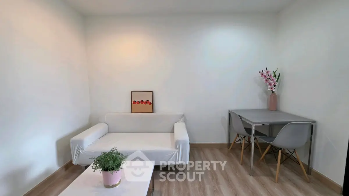 Charming minimalist living room with cozy white sofa and modern dining area, perfect for relaxation and entertaining.