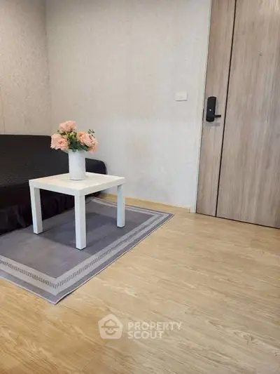 Cozy interior with modern decor and wooden flooring, featuring a stylish table and elegant floral arrangement.