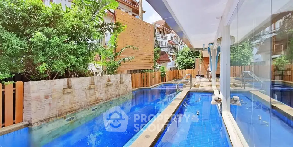 Luxurious residential pool area with modern design and lush greenery.