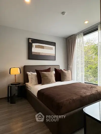 Modern bedroom with large window and stylish decor in a luxury apartment.