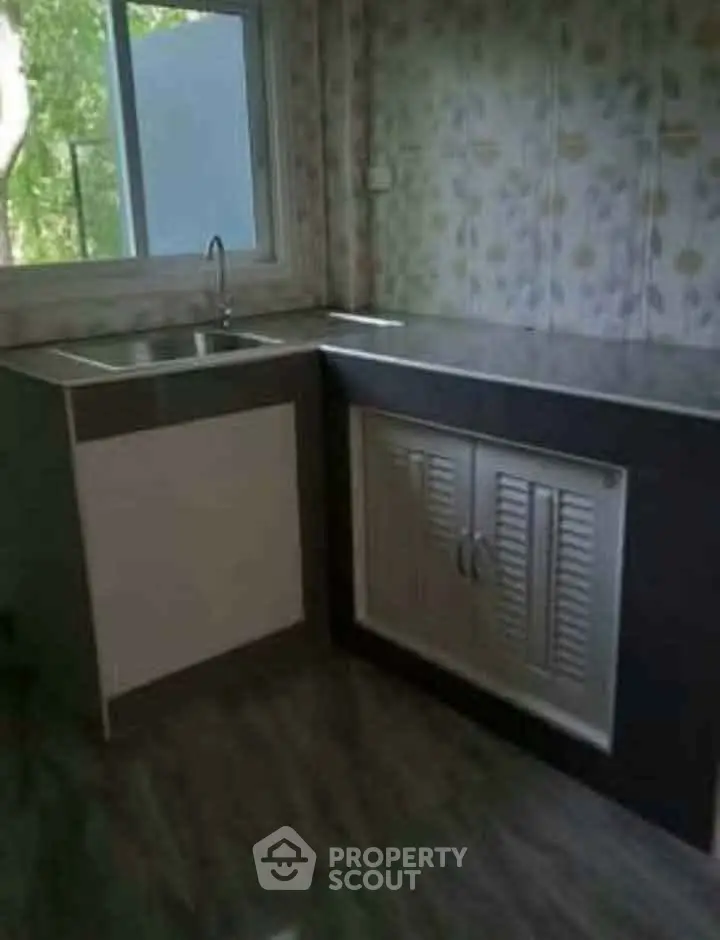 Compact kitchen with modern sink and window view, ideal for cozy apartments.