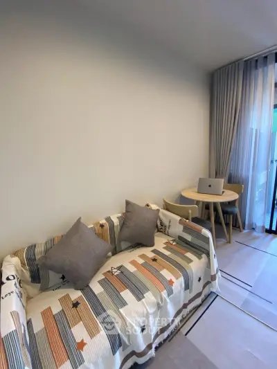 Modern living room with stylish sofa and cozy dining area near balcony.