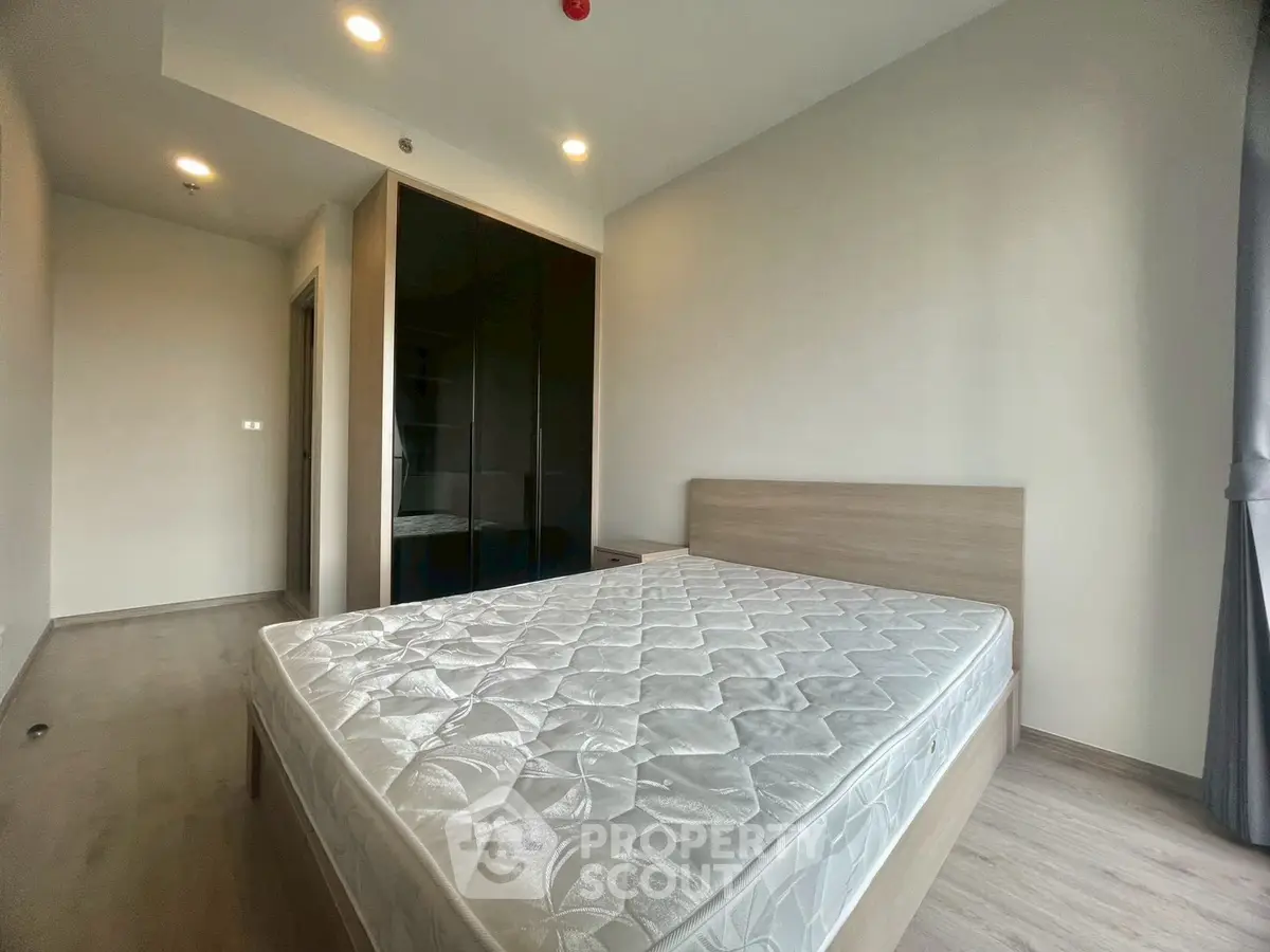 Spacious bedroom with modern design and large window for natural light.