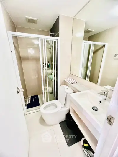 Modern bathroom with sleek shower and contemporary fixtures in a stylish apartment.