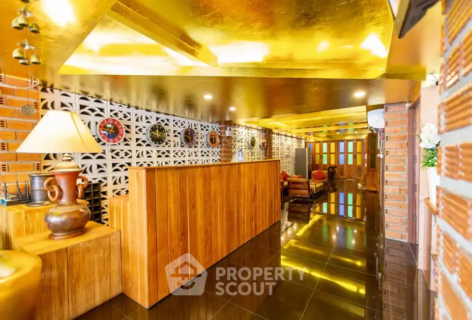 Luxurious hotel lobby with golden ceiling and elegant wooden decor