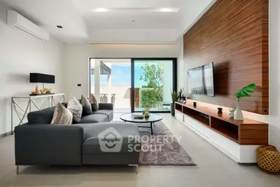 Modern living room with sleek furniture and large sliding doors to balcony.