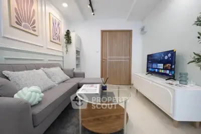 Modern living room with stylish decor and smart TV, featuring a cozy gray sofa and elegant wall art.