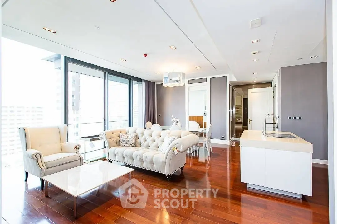 Luxurious open-plan living room with elegant furniture and modern kitchen in high-rise apartment.
