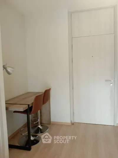 Modern study nook with sleek desk and chairs in minimalist apartment.