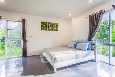 Bright and airy bedroom with large windows and garden view