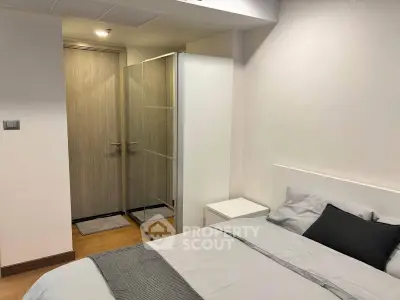 Modern bedroom with minimalist design and ensuite bathroom in a stylish apartment.