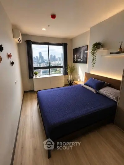 Modern bedroom with city view, featuring stylish decor and natural light, perfect for urban living.