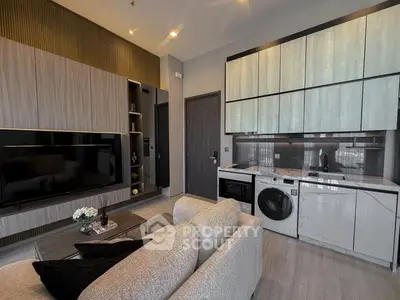 Modern living room with integrated kitchen featuring sleek cabinetry and built-in appliances.