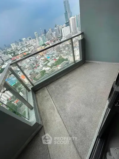 Spacious balcony with stunning city skyline view in modern high-rise apartment.