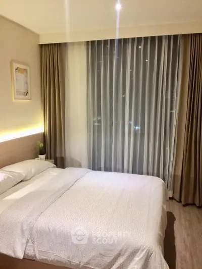 Cozy bedroom with modern decor and large window with curtains