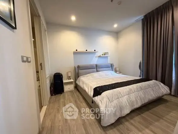 Modern bedroom with cozy decor and elegant lighting, featuring a comfortable bed and stylish wooden flooring.