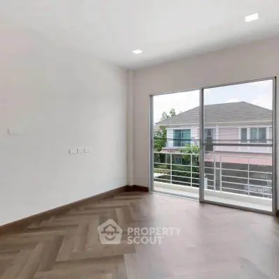 Spacious empty room with large window and balcony view in modern home