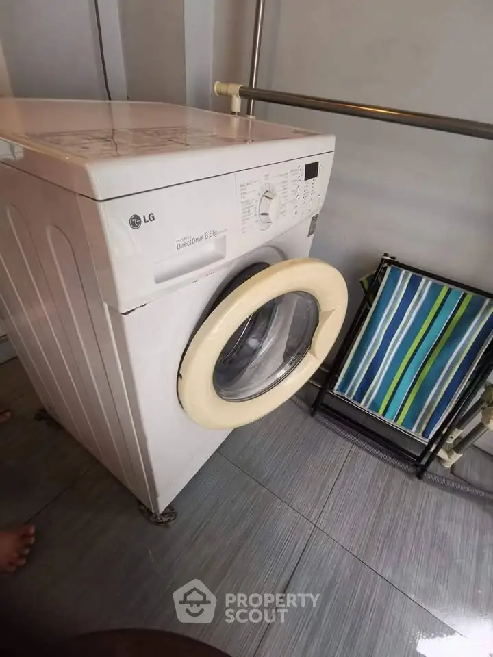 Compact laundry area with washing machine and folding chair