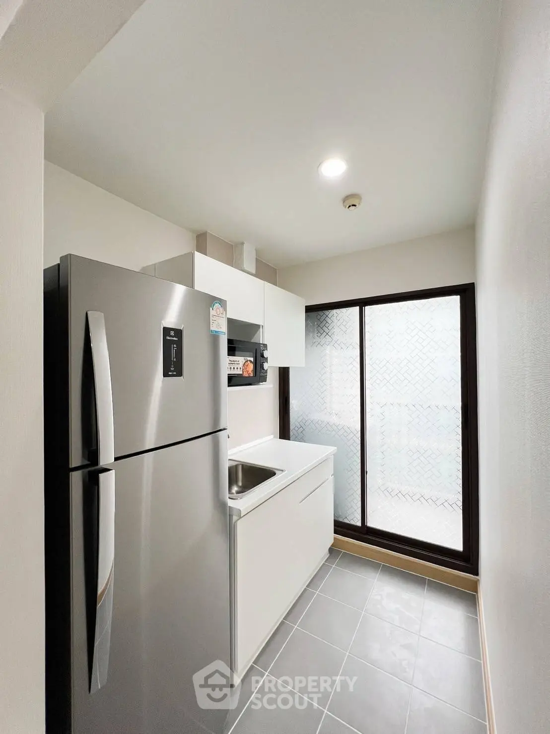 Modern compact kitchen with sleek appliances and natural light