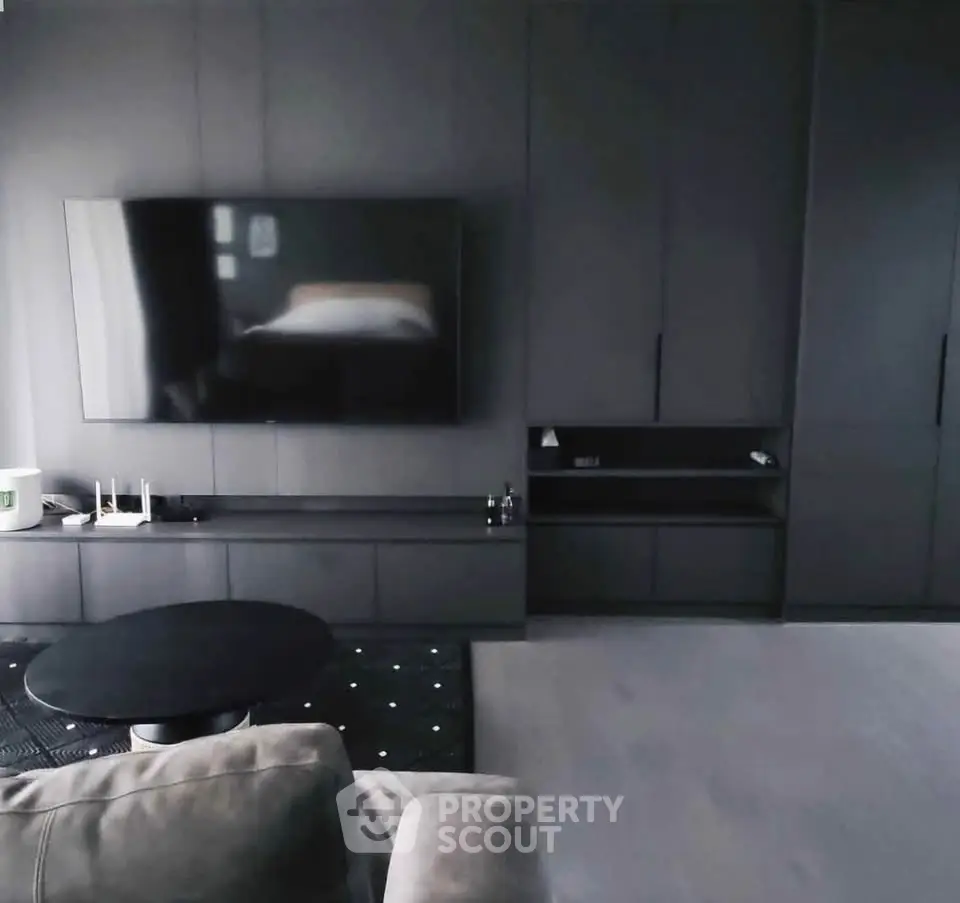 Modern living room with sleek black cabinetry and wall-mounted TV