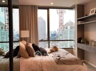 Luxurious bedroom with stunning city view and modern decor in high-rise apartment.