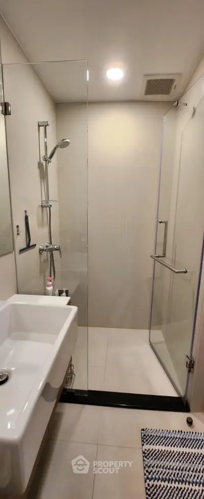 Modern bathroom with glass shower enclosure and sleek fixtures