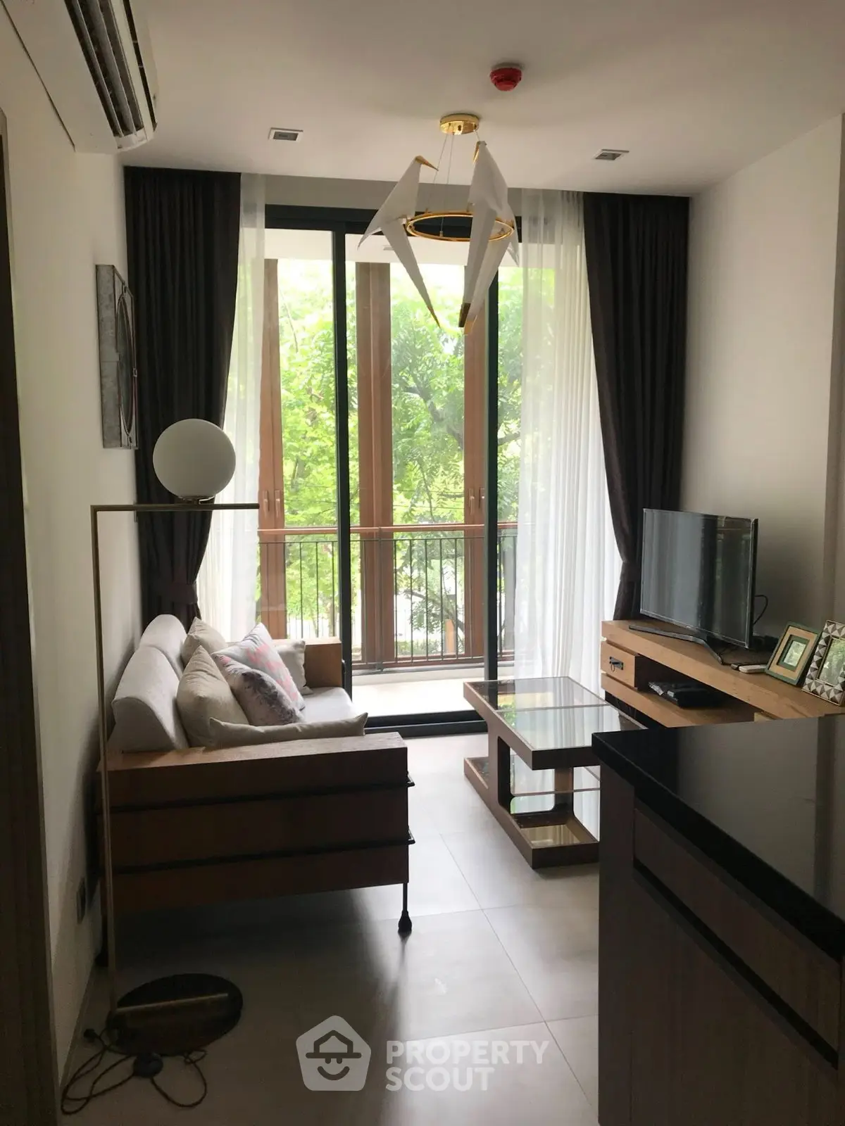 Modern living room with large window and stylish decor in a cozy apartment.